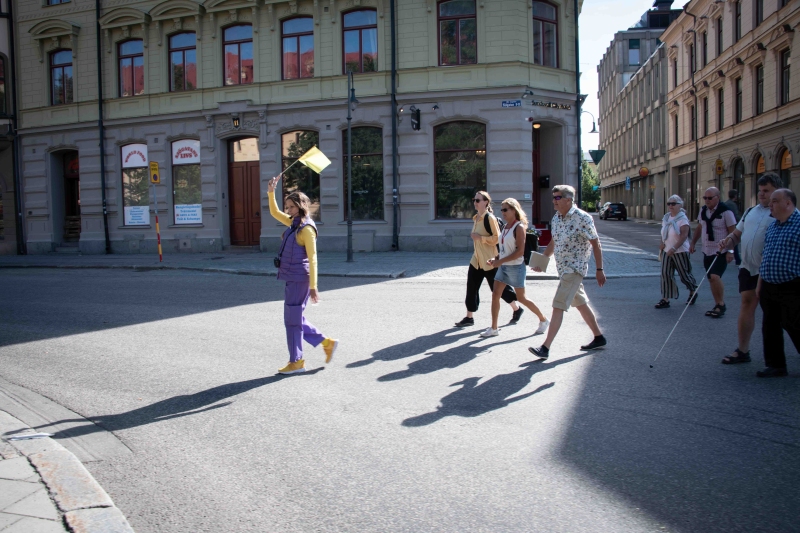 Guide with a yellow flag followed by city tour participants